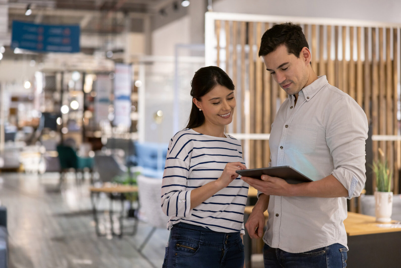 Retail clerk helping a woman shopping at a furniture store