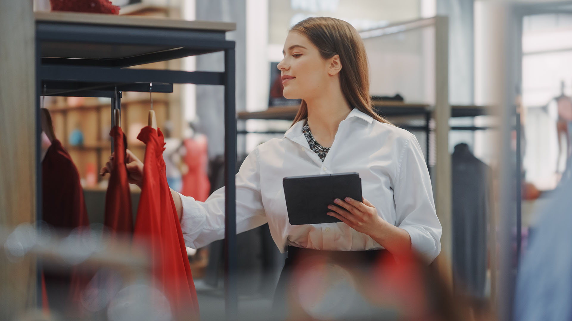 Clothing Store: Businesswoman and Visual Merchandising Specialist Uses Smartphone To Create Stylish Collection. Fashion Shop Sales Retail Manager Checks Stock. Small Business Owner and Designer Works